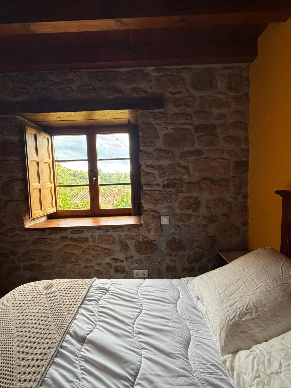 Dormitorio con pared de piedra